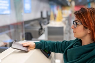 Woman presents passport at an airport counter