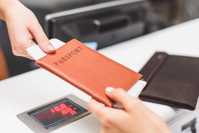 Female Handing Passport at Airport Check-in