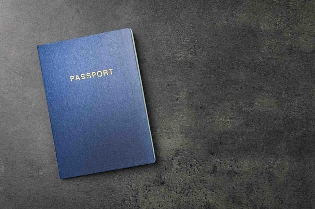 Top View of a Blue Passport on a Dark Gray Table