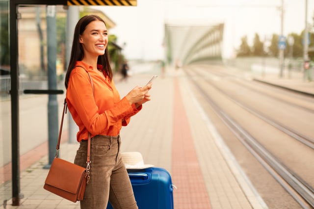 Travelers Checking Their Documents On A Smartphone With Suitcases Nearby In The Uk