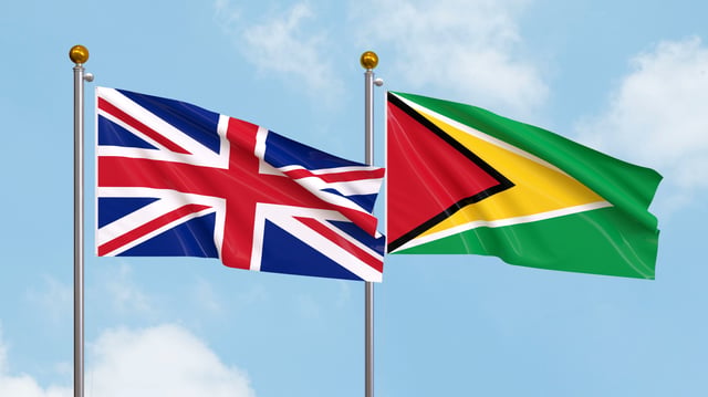 United Kingdom and Guyana flags waving