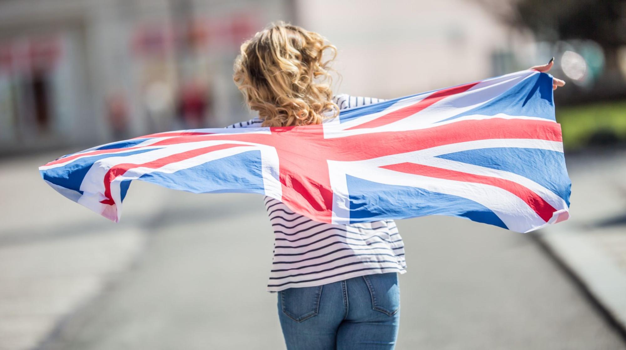 Attractive happy young girl with the flag of the Great Britain